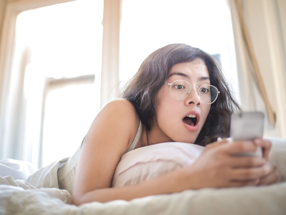 girl with phone in bed