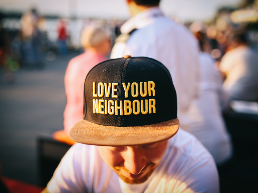 Man in a cap “love your neighbour”